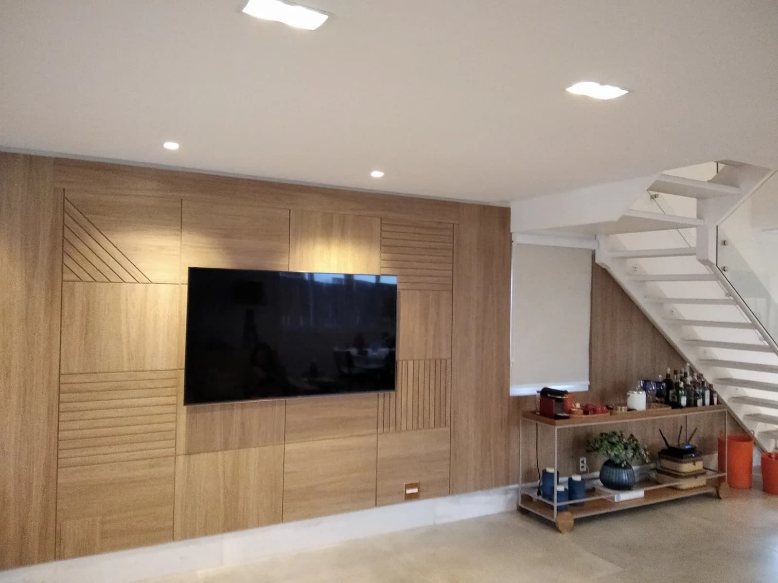 Painel de parede em madeira do chão ao teto com televisor embutido